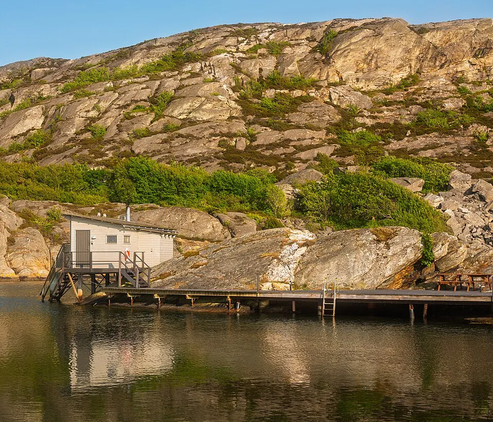 Sauna an stillem Wasser im Abendlicht